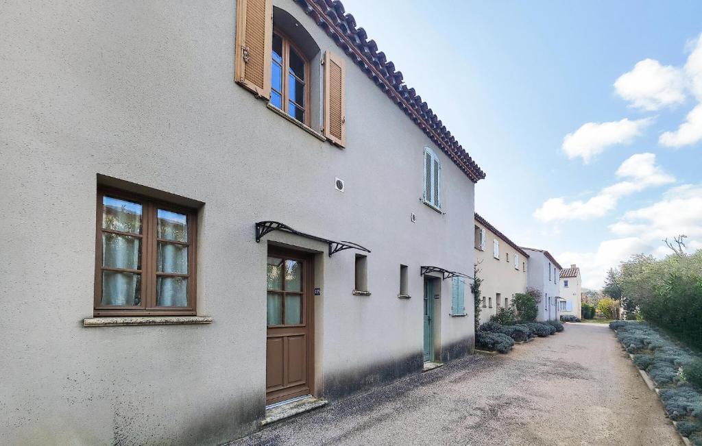 a white building with a door and windows on it at Lovely Home In Stlaurent-De-La-Cabr in Saint-Laurent-de-la-Cabrerisse