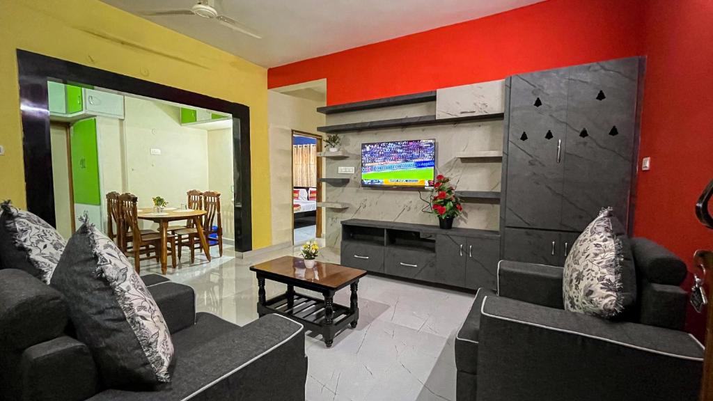 uma sala de estar com dois sofás e uma televisão em S V IDEAL HOMESTAY -2BHK SERVICE APARTMENTS-AC Bedrooms, Premium Amities, Near to Airport em Tirupati