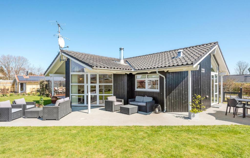 Casa negra con sillas y patio en 3 Bedroom Pet Friendly Home In Juelsminde, en Sønderby