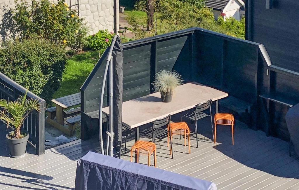 a table and two chairs on a deck with a table and stools at Awesome Home In Sandvika With House A Panoramic View in Sandvika