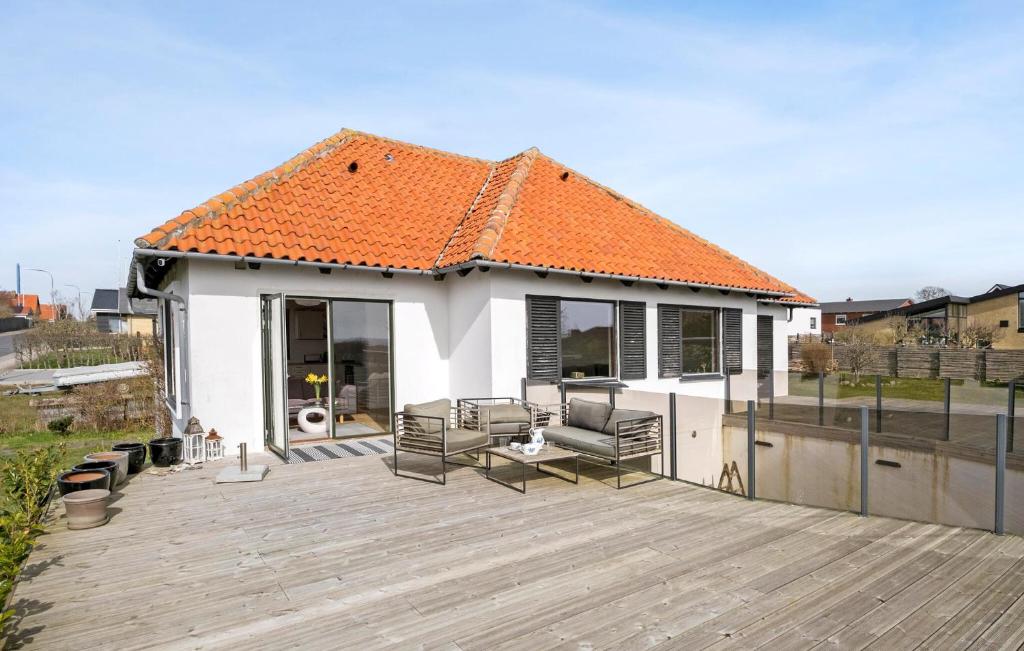 a house with an orange roof with a wooden deck at Amazing Home In Korsr With House Sea View in Korsør