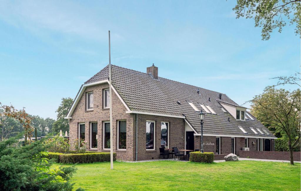 a large brick house with a lawn in front of it at 3 Bedroom Stunning Home In Fluitenberg in Fluitenberg