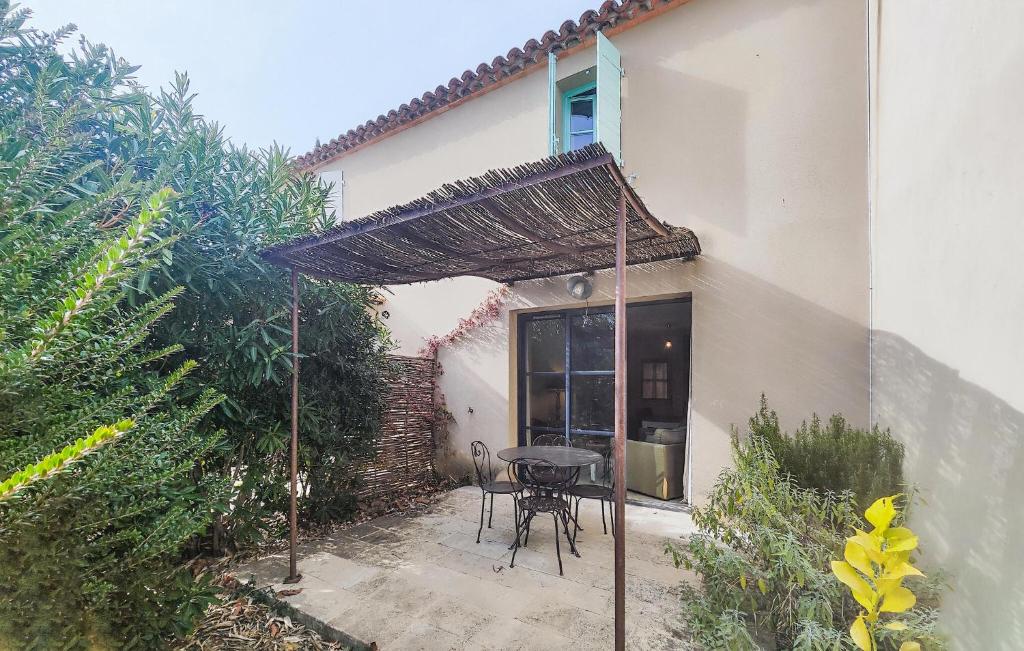 a patio with a table and chairs under an umbrella at Nice Home In Saint-Laurent-De-La-Ca in Saint-Laurent-de-la-Cabrerisse