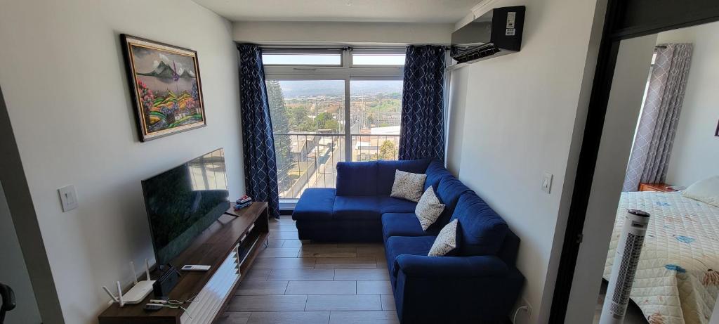 a living room with a blue couch and a tv at Apartamento Parada 50 in Guatemala