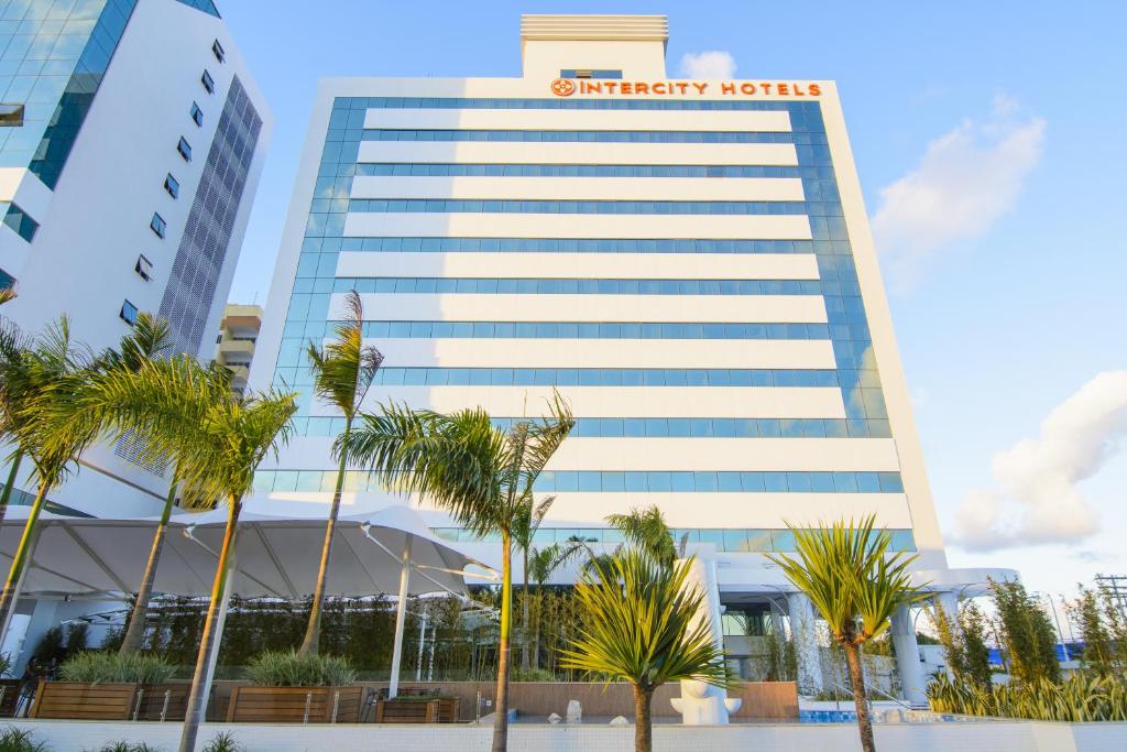 ein hohes Gebäude mit einem Schnitzel-Hotel in der Unterkunft Intercity Salvador Aeroporto in Lauro de Freitas