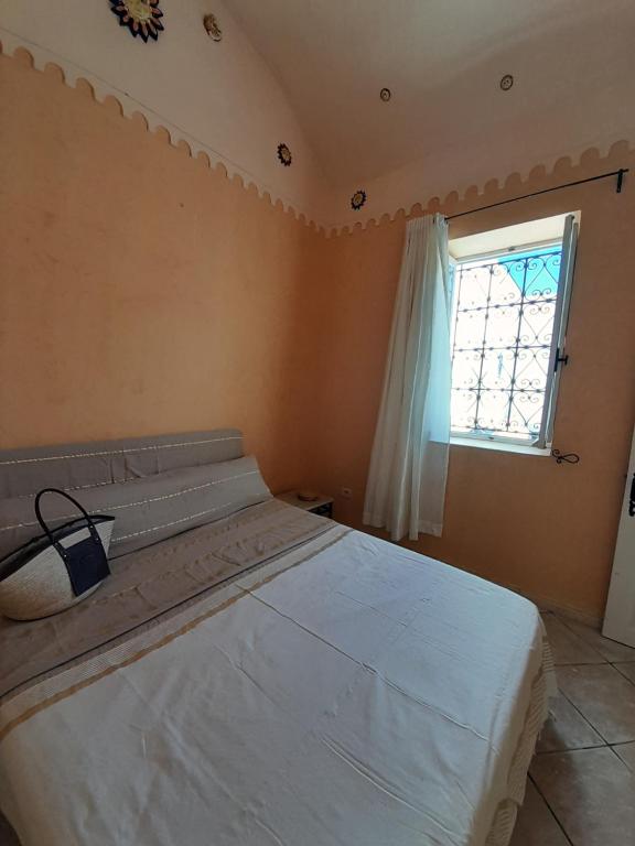 Un dormitorio con una cama grande y una ventana en Dar Rita en Houmt El Souk