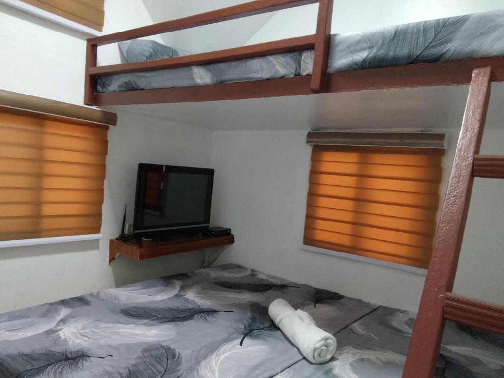 a bedroom with two bunk beds and a television at VILLA ALESSA in Vigan
