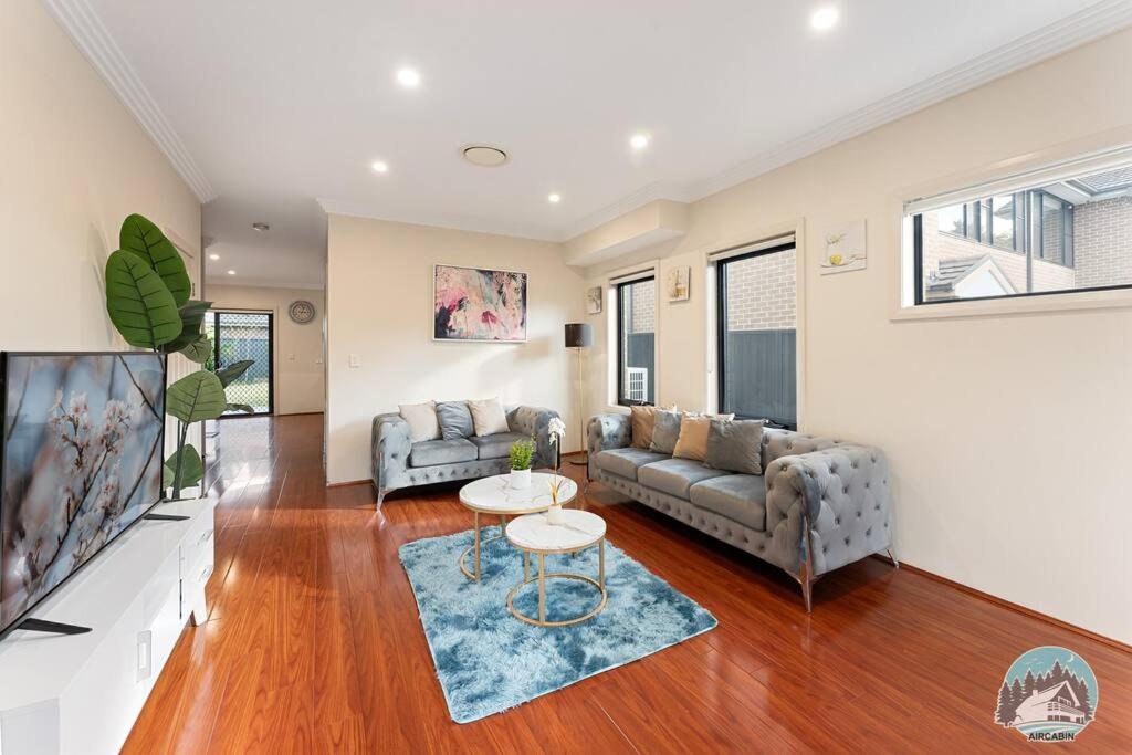 a living room with two couches and a table at Aircabin - Carlingford - Sydney - 4 Beds House in Sydney