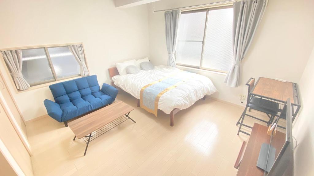 una camera da letto con un letto e una sedia blu di CON-TWO 201 a Tokyo