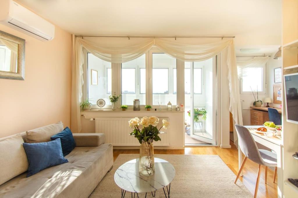 uma sala de estar com um sofá e uma mesa em Cosy and elegant flat with spectacular city view em Zagreb