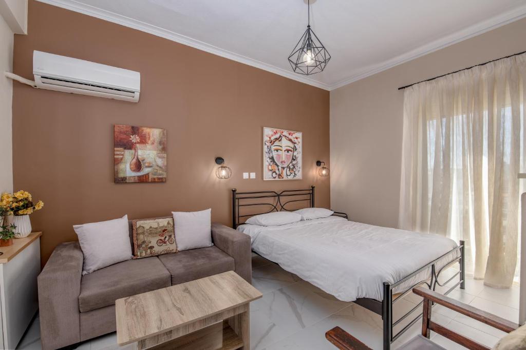 ein Schlafzimmer mit einem Bett und einem Sofa in der Unterkunft Marina Zeas Skydeck in Piräus