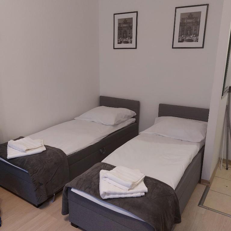 two beds in a small room with towels on them at Apartament Mazurska in Kętrzyn