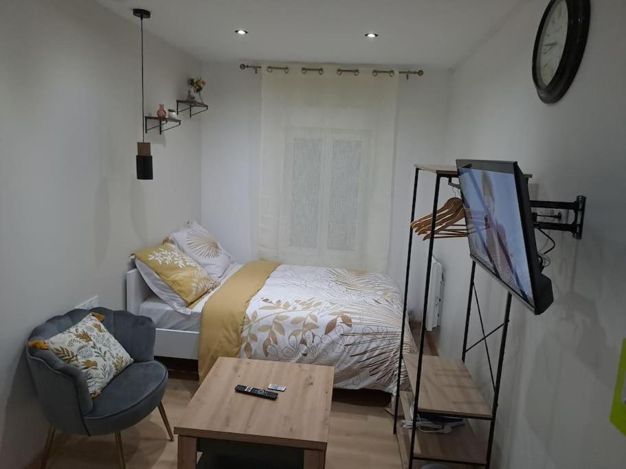 ein Schlafzimmer mit einem Bett, einem Tisch und einem Stuhl in der Unterkunft Sweet / Circuit 24h / Moto GP / Antares / Oasis - centre des expositions / Boulerie Jump in Le Mans