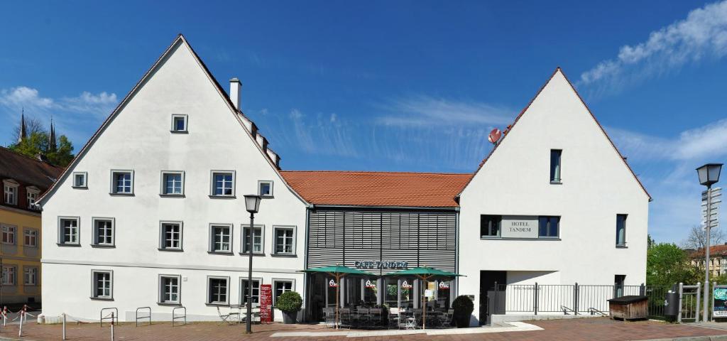 ein großes weißes Gebäude mit zwei spitzen Ohren in der Unterkunft Tandem Hotel in Bamberg