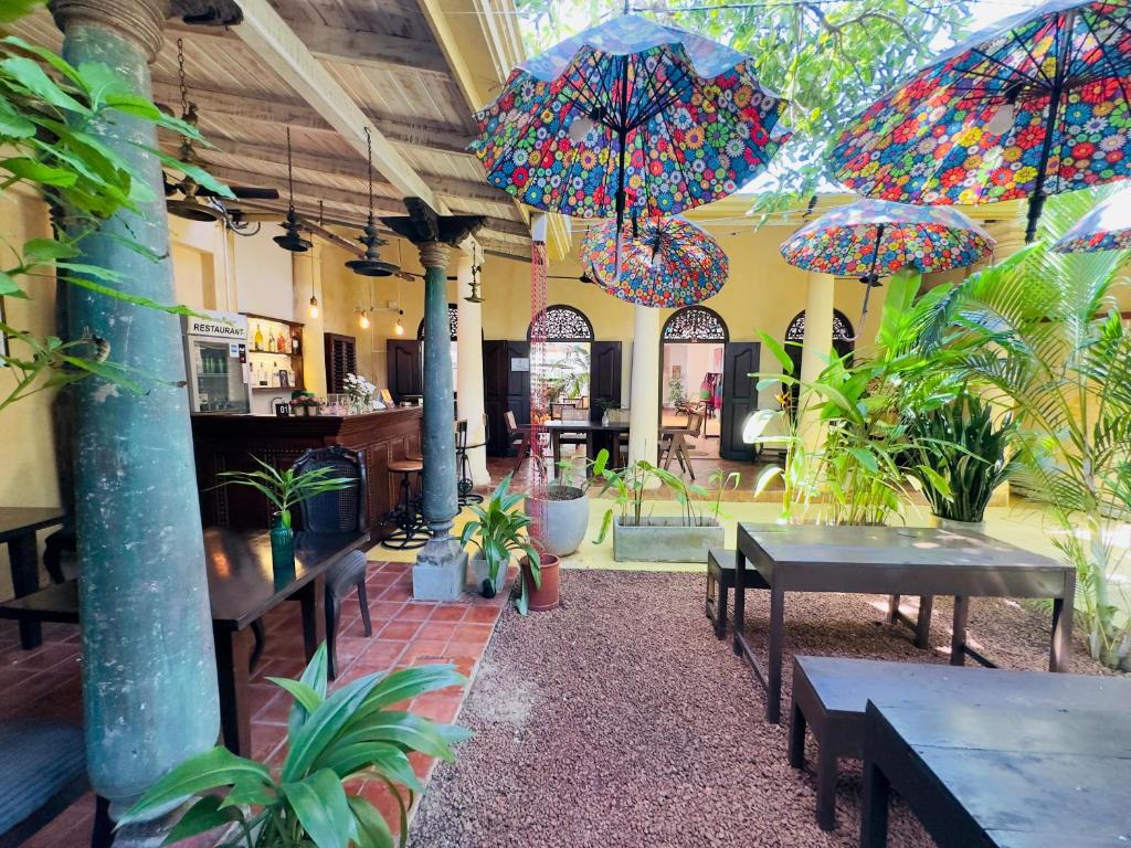 a patio with tables and umbrellas in a restaurant at Mango House - Galle Fort in Galle