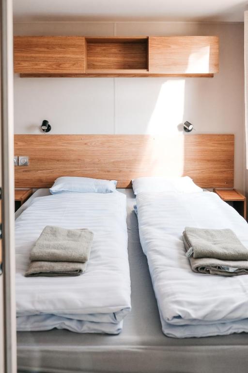 two beds in a room with towels on them at Pivoine Camping Belle-Vue 2000 in Berdorf