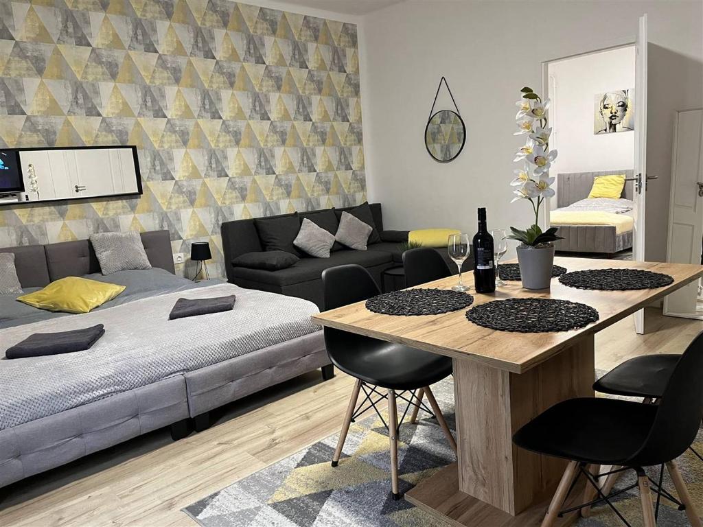 a living room with a bed and a table with chairs at Bereg Szíve Apartman in Vásárosnamény