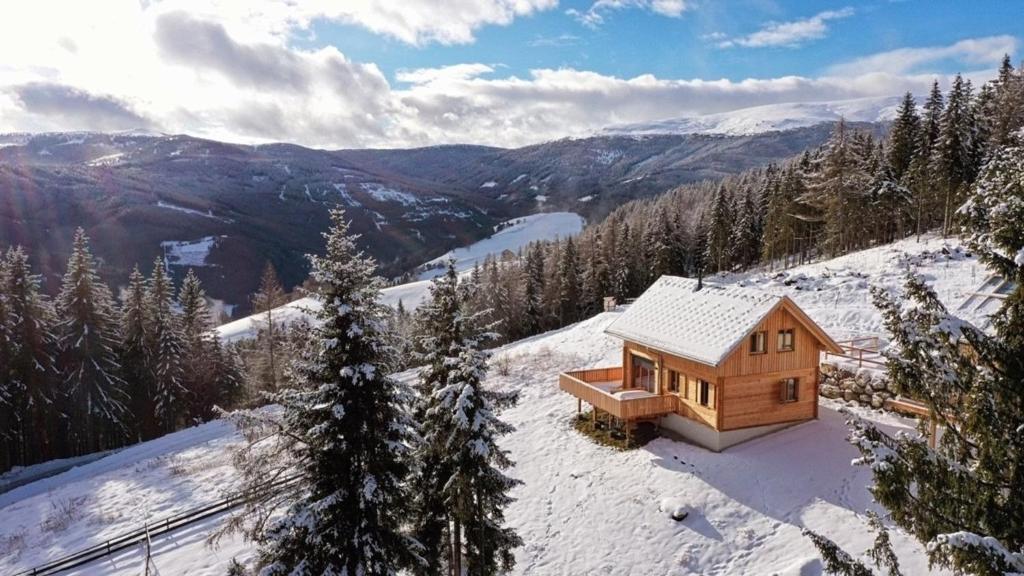 a wooden cabin on top of a snow covered mountain at Holzfäller-Chalet in Obdach