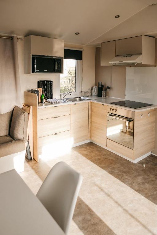 a kitchen with wooden cabinets and a stove top oven at Magnolia - Camping Belle-Vue in Berdorf