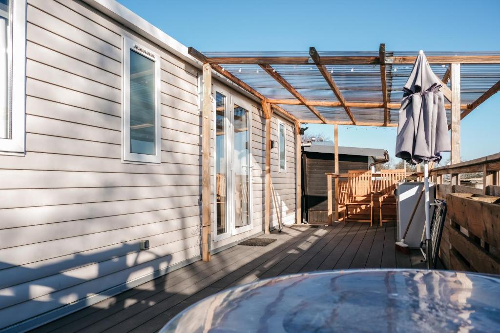 a deck with an umbrella and a swimming pool at Magnolia - Camping Belle-Vue in Berdorf