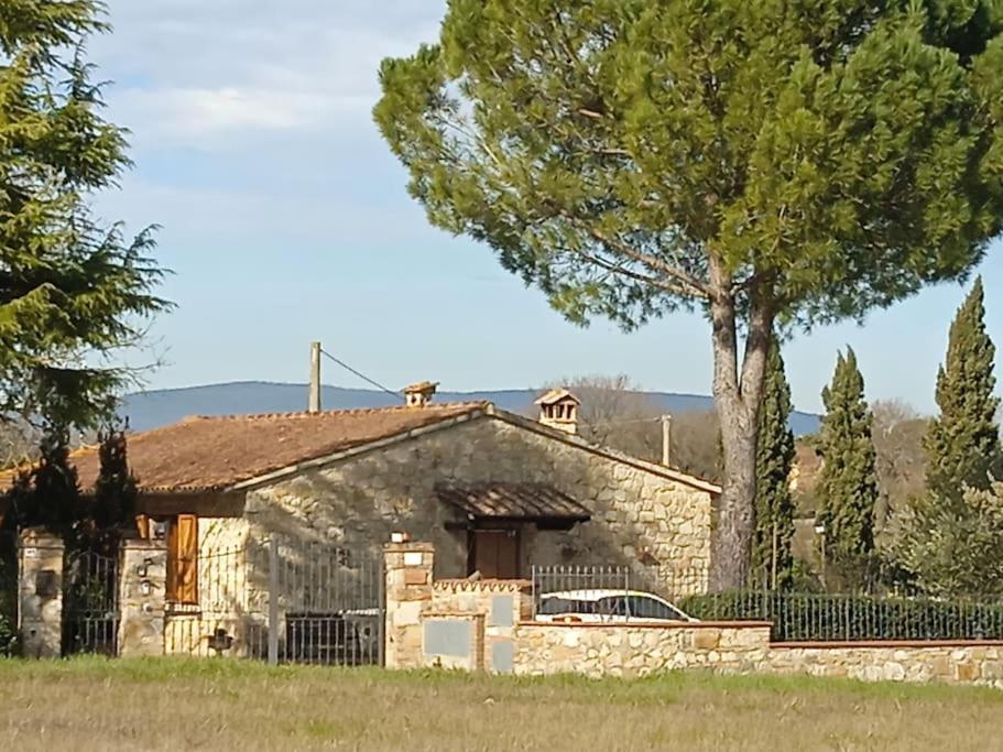 a stone house with a car parked in front of it at Villetta con parco vicino San Gimignano in Le Grazie