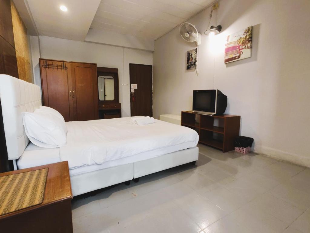 a bedroom with a white bed and a television at Panda House Chiang Mai in Chiang Mai