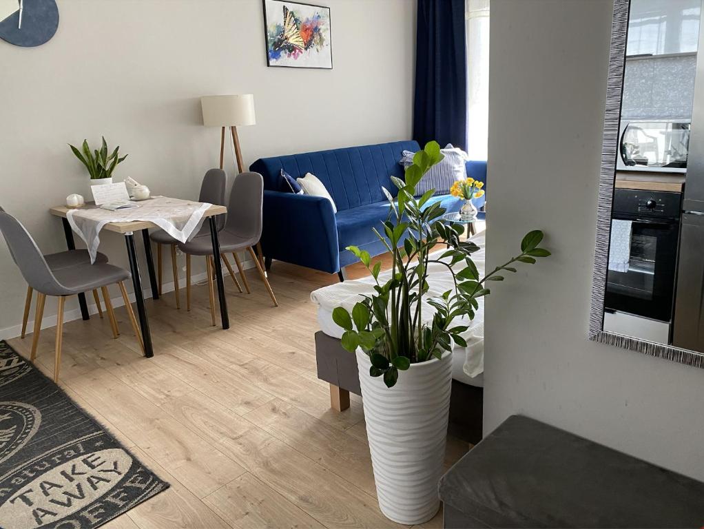 a living room with a blue couch and a table at Apartament Mielczarskiego Tanie spanie Elbląg in Elblag