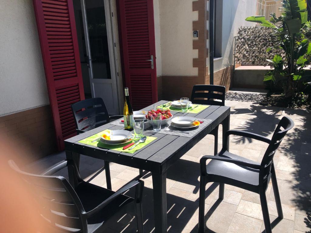 un tavolo con un piatto di cibo e una bottiglia di vino di Appartamento La Pineta a Marina di Cecina