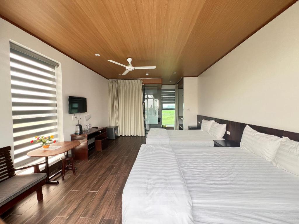 Habitación de hotel con 2 camas y mesa en HOMESTAY THIÊN CÂM en Cẩm Xuyên