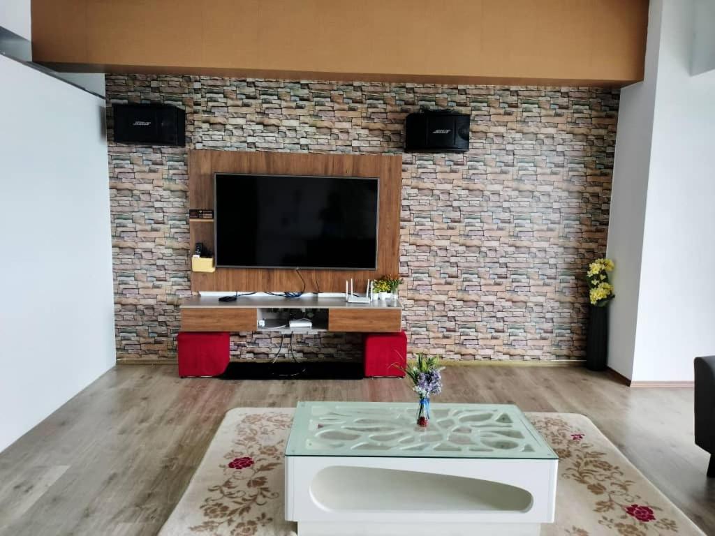 uma sala de estar com televisão e uma parede de tijolos em The Venus Block B31st floor Sri Manjung em Kampong Lumut Kiri