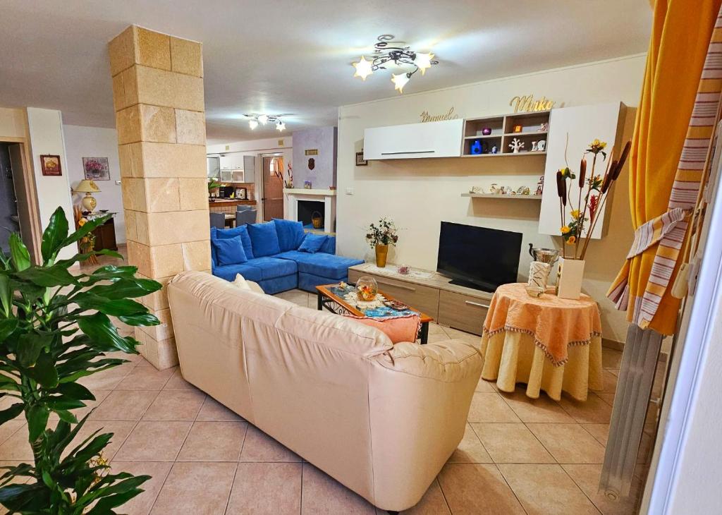uma sala de estar com um sofá azul e uma televisão em B&B VILLA MARINA em Castrignano del Capo