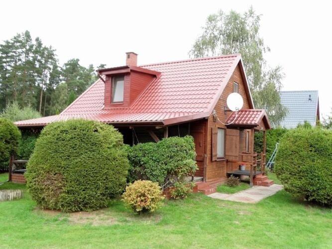 Holiday home in Kopalino في كوبالينو: منزل صغير بسقف احمر وبعض الاشجار