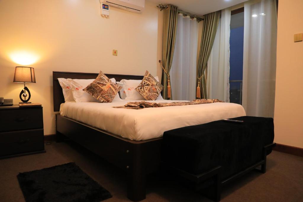 een slaapkamer met een groot bed en een raam bij Precious Villas Lubowa in Kampala