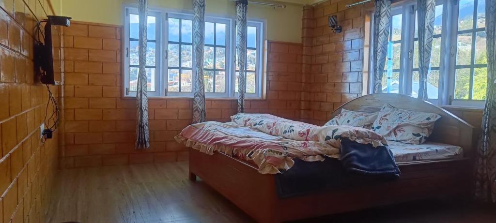 a room with a bed in a room with windows at ND HOMESTAY in Tawang