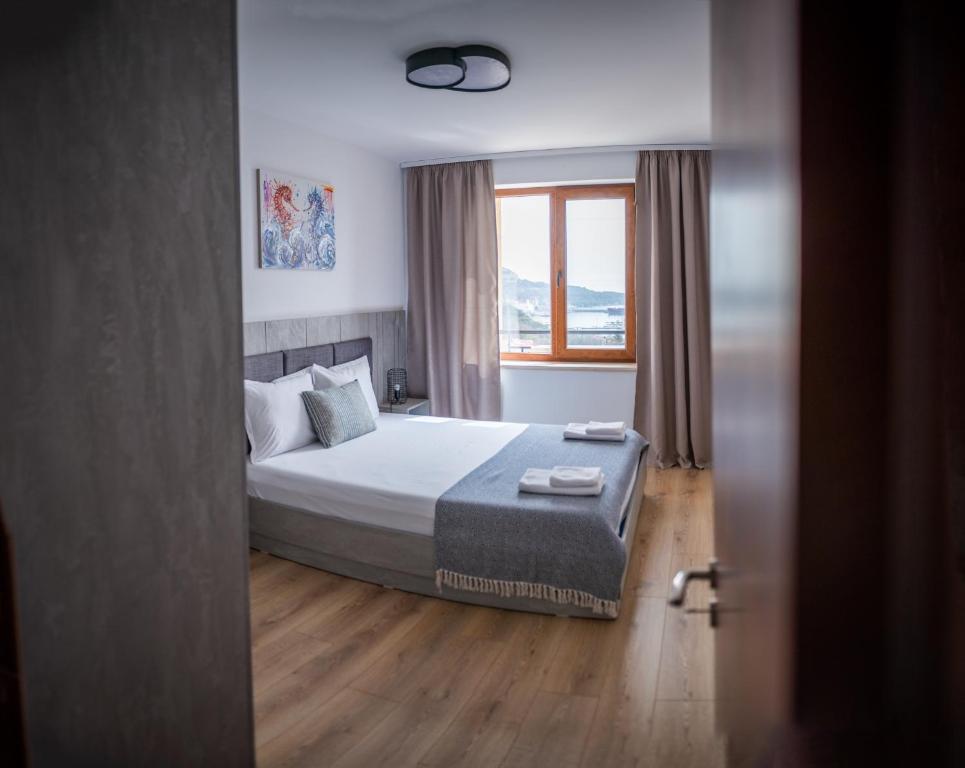 a bedroom with a large bed with a window at Queen's Palace Balchik apartment in Balchik