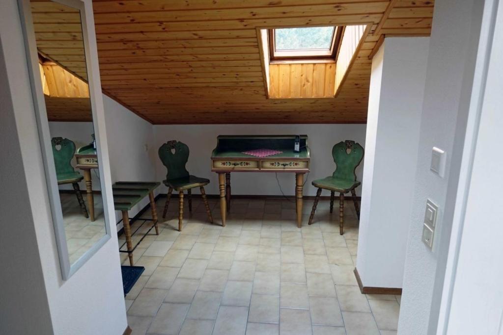 a room with a table and green chairs in a attic at FeWo-Franzi 1-4 Persca45qmDG in Buching