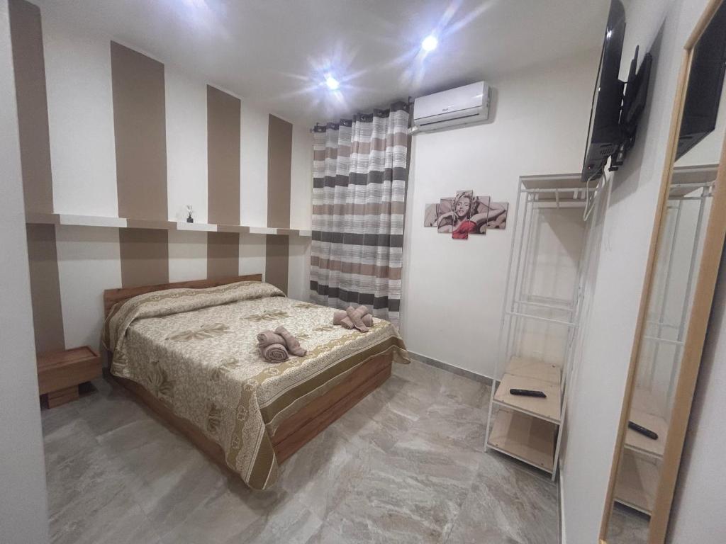 um quarto com uma cama e uma televisão num quarto em Al piccolo borgo em Catânia