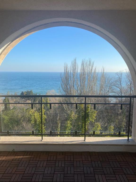 an archway in a building with a view of the ocean at Queen's Garden Balchik apartment in Balchik
