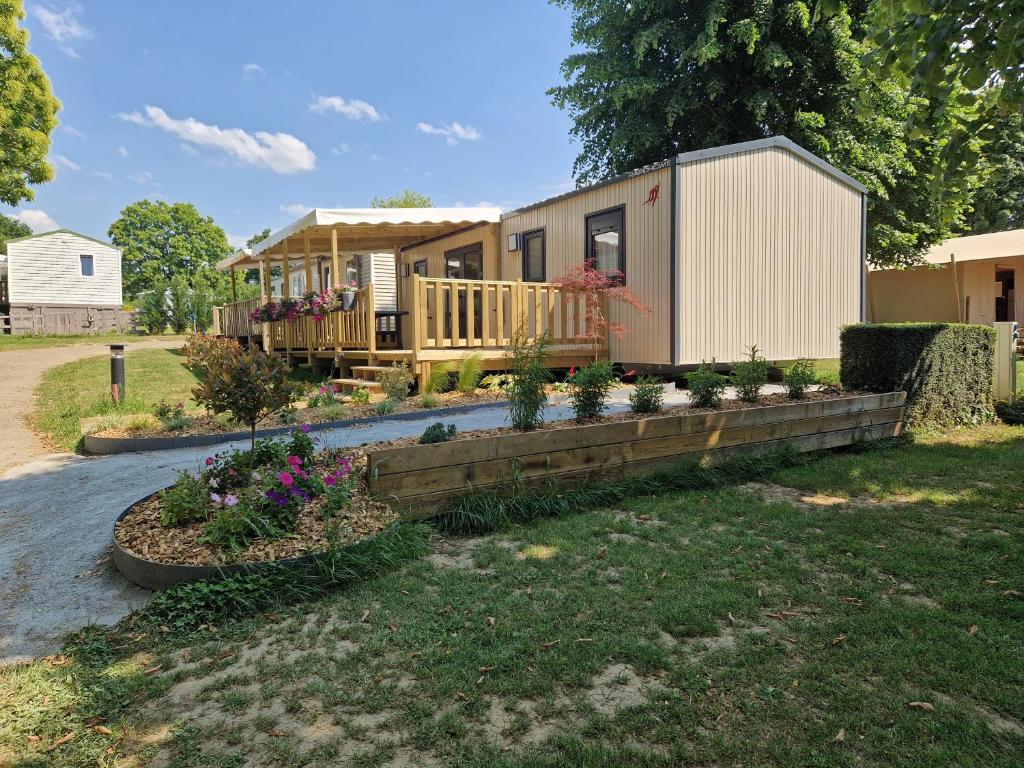ein Mobilheim mit Blumen im Hof in der Unterkunft camping les rives du lac in Bois Morin