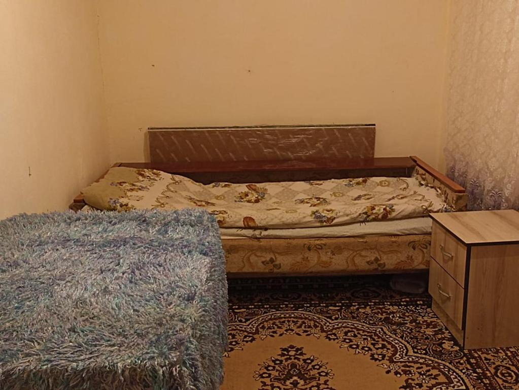 a small bedroom with a bed and a dresser at Talgat & Kaabal in Kara-Agach