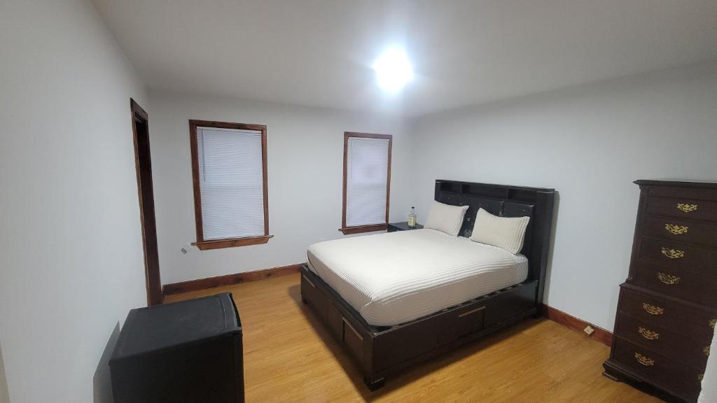 ein Schlafzimmer mit einem Bett, einer Kommode und einem TV in der Unterkunft Entire house - 4 Bedroom-Enfield in Enfield