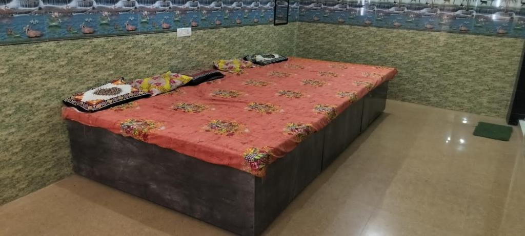 uma cama num quarto com uma colcha vermelha em Mohan marrige lawn em Faizābād