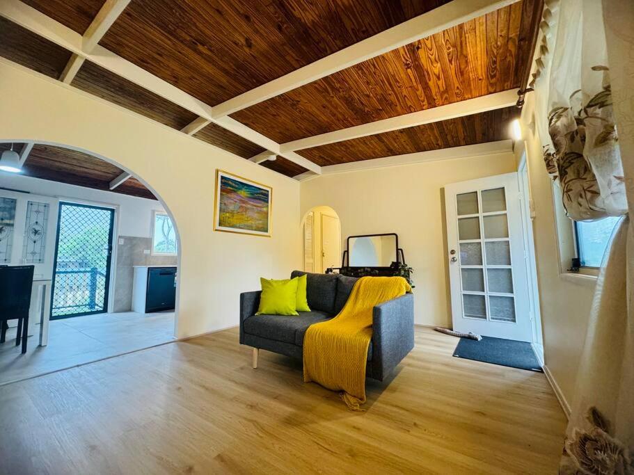 a living room with a couch and a wooden ceiling at Folk-style Waterford 3 bdr-house in Kingston