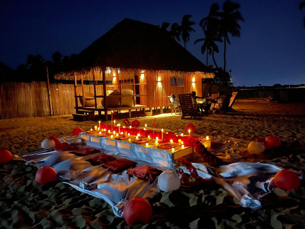 Cadjèhoun的住宿－TATA BEACH，一群人躺在沙滩上,放着蜡烛