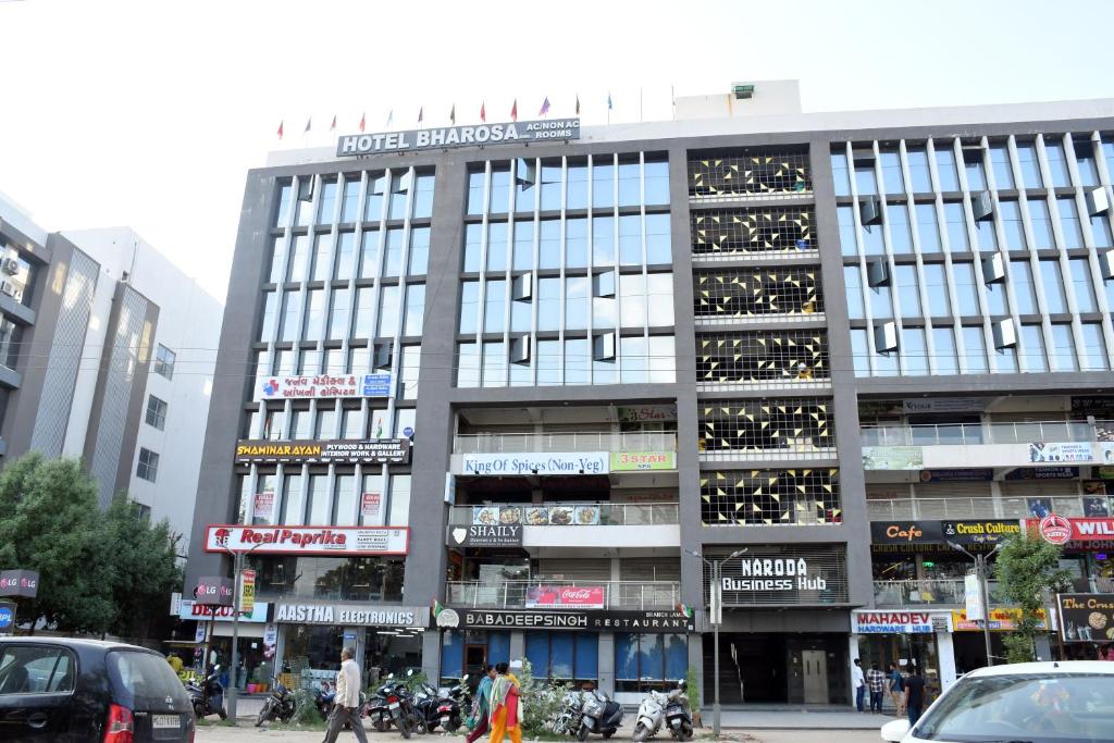 un gran edificio con gente caminando delante de él en Hotel Bharosa inn Naroda en Ahmedabad