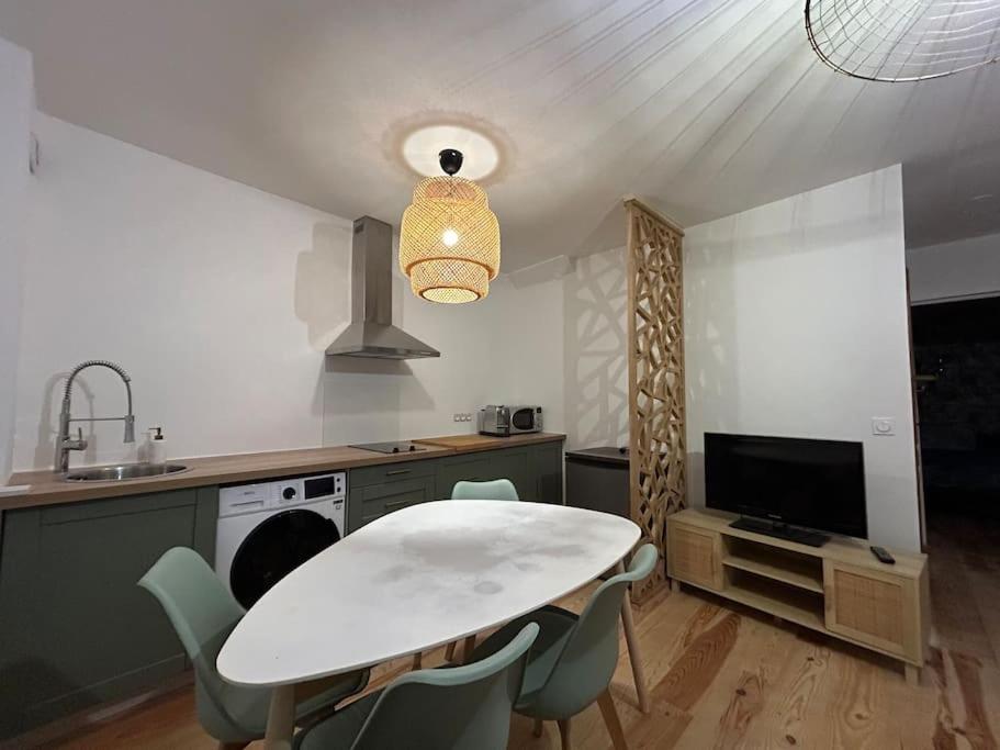 une cuisine avec une table et des chaises dans une cuisine dans l'établissement Le floral, à Carcassonne