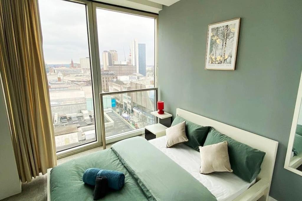 a bedroom with a bed and a large window at Birmingham City Centre, 2 bedroom Apartment, in Birmingham