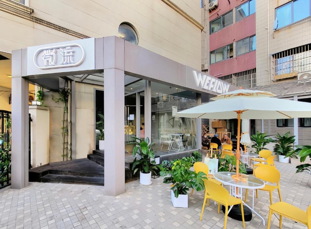 a restaurant with a table and chairs and an umbrella at WeFlow Youth Hostel - Shanghai People's Square Jing'an Joy City in Shanghai