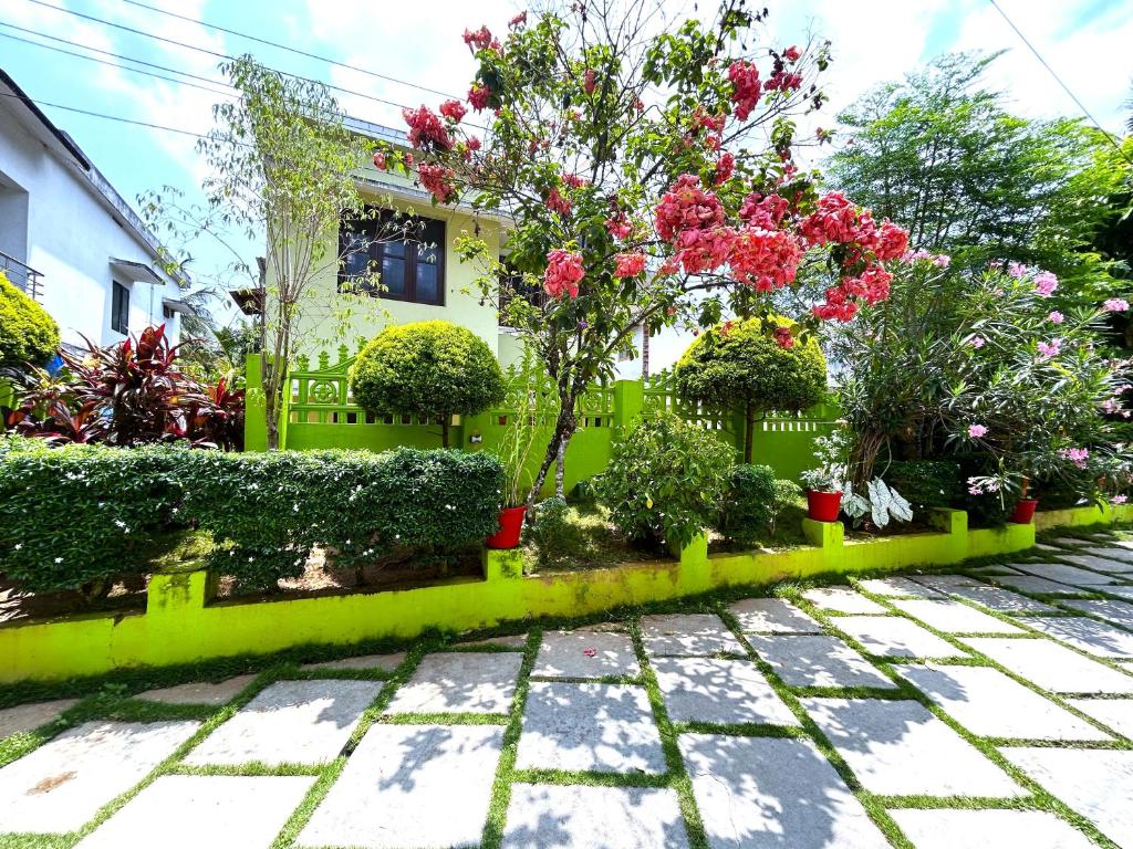 a garden with flowers and plants in front of a house at Deluxe Residency in Kalpetta