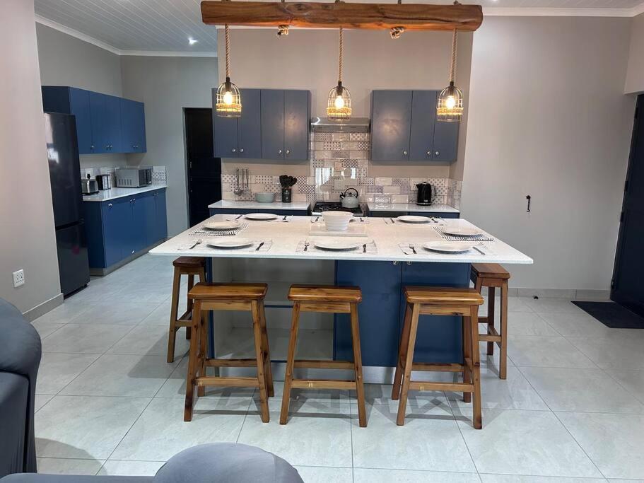 a kitchen with blue cabinets and a large island with bar stools at Saldeseas in Strandfontein